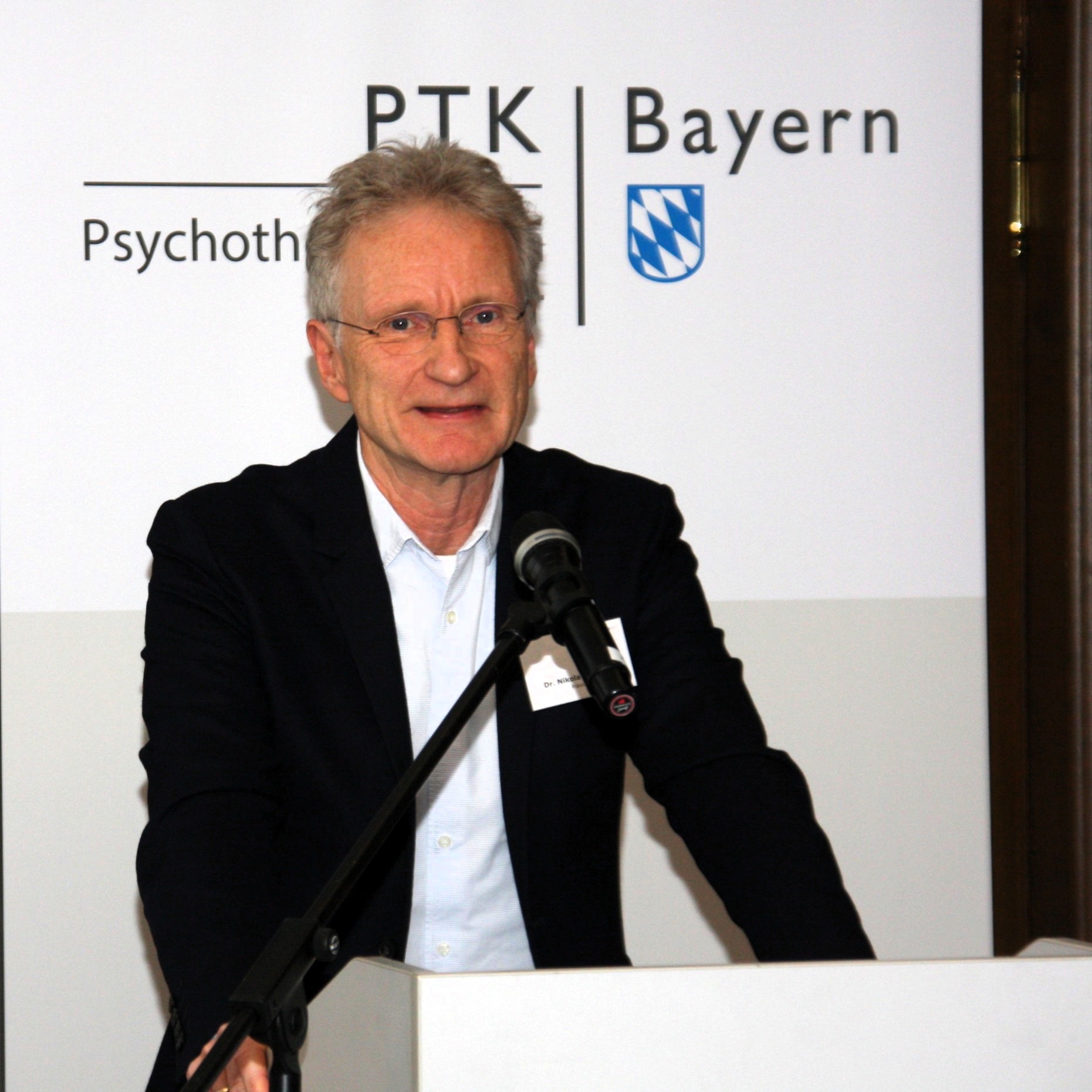 Ein Mann steht an einem Redepult.